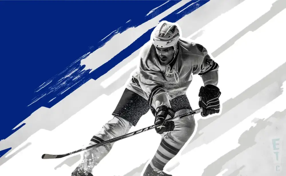 A hockey player in full gear skates forward with a stick.