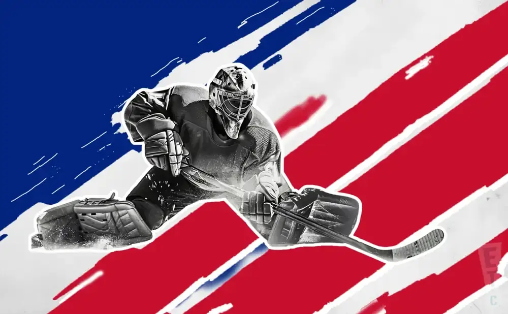 A hockey goalie in full gear makes a save against a backdrop of red and white stripes and a blue section.