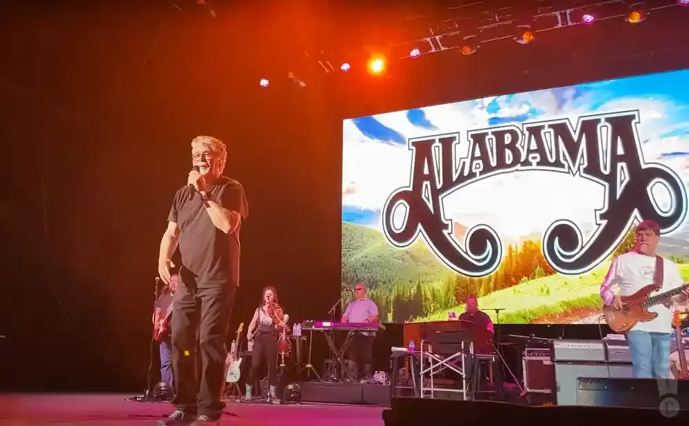 Lead singer of Alabama on stage, holding a microphone.