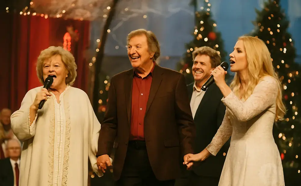 A group of singers perform on stage with Christmas trees in the background.