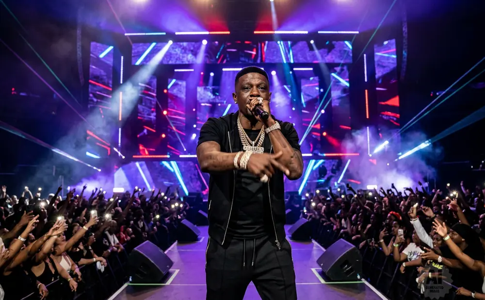 A rapper performs on stage with bright lights and a cheering crowd.