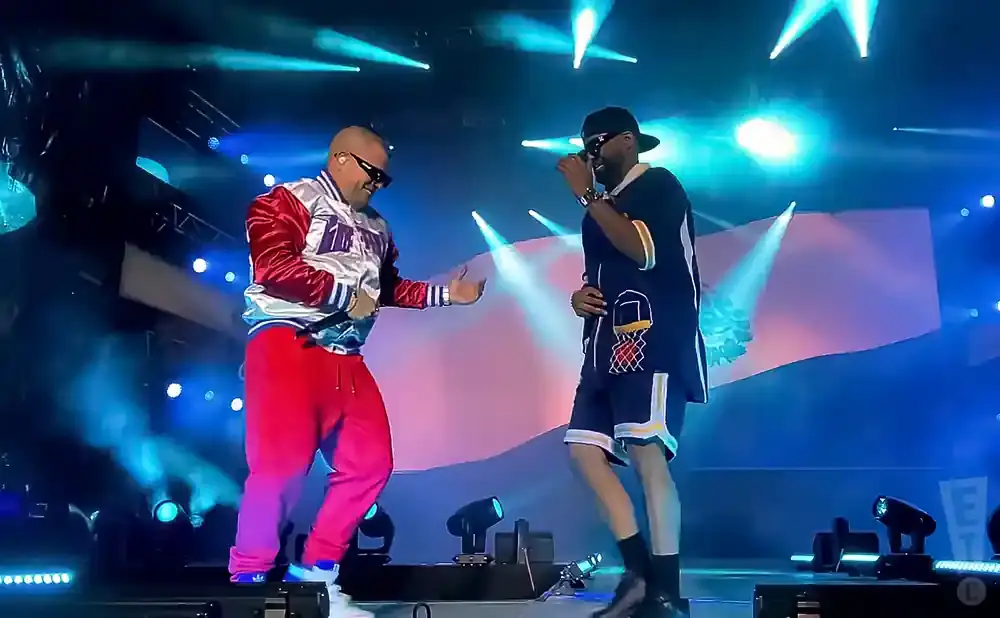Two men performing on stage under blue lights.