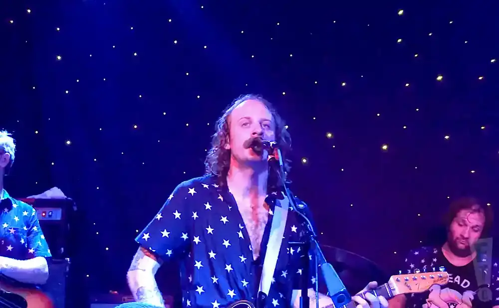 A band plays on a stage with a starry blue backdrop.