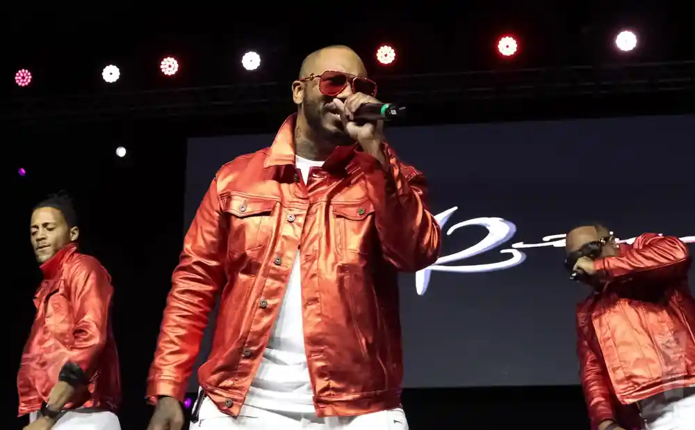 Rapper The Game and backup dancers perform on stage in matching red jackets.