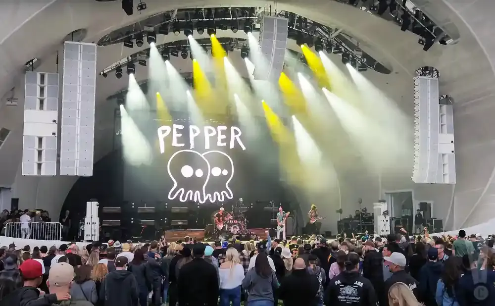 A band named Pepper performs on stage with lights and speakers.