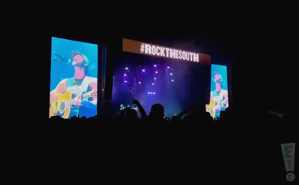 A concert screen shows a musician playing guitar, with #ROCKTHESOUTH displayed above the stage.