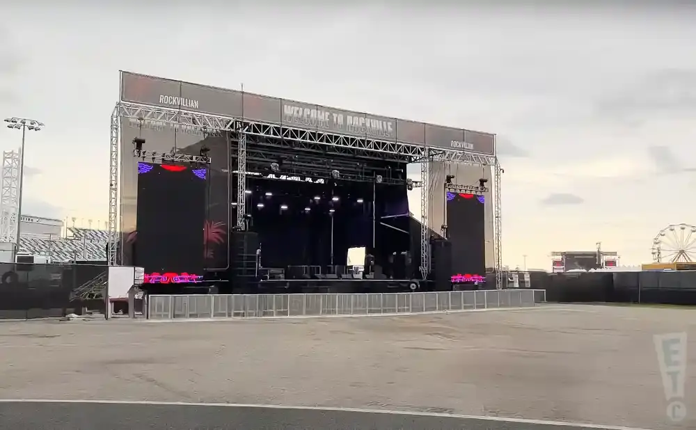 An outdoor concert stage with large screens and 