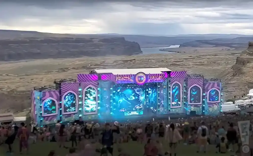A large outdoor stage with purple and pink decor at the 
