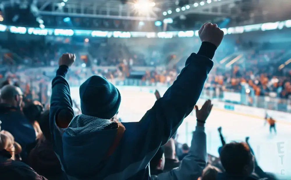Fans cheer with hands raised in a brightly lit hockey arena, with the ice visible below.