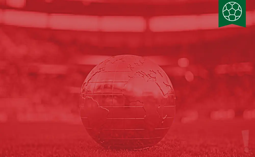 A red-tinted globe sits on grass with a blurred stadium in the background, a soccer ball emblem in the top right.