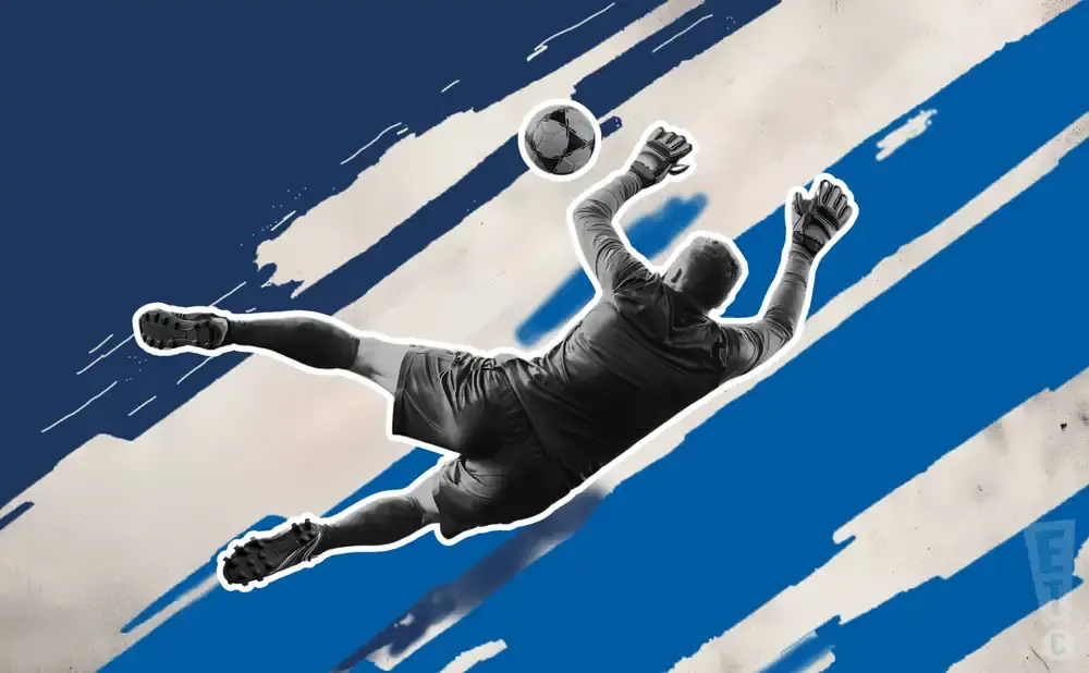 Goalkeeper dives to catch a soccer ball against a backdrop of blue and white stripes.
