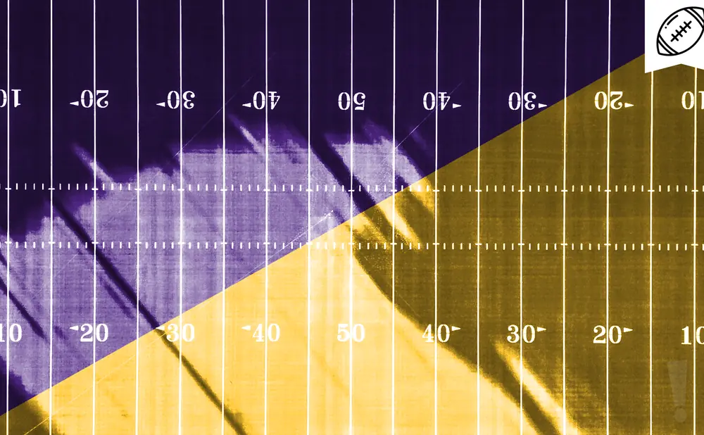 A football field with purple on the left and gold on the right, divided diagonally.