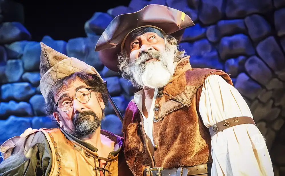 Two men in medieval costumes, one with glasses and a pointed hat, the other with a pirate hat and beard.