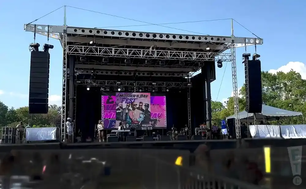 Outdoor concert stage with a large screen displaying 