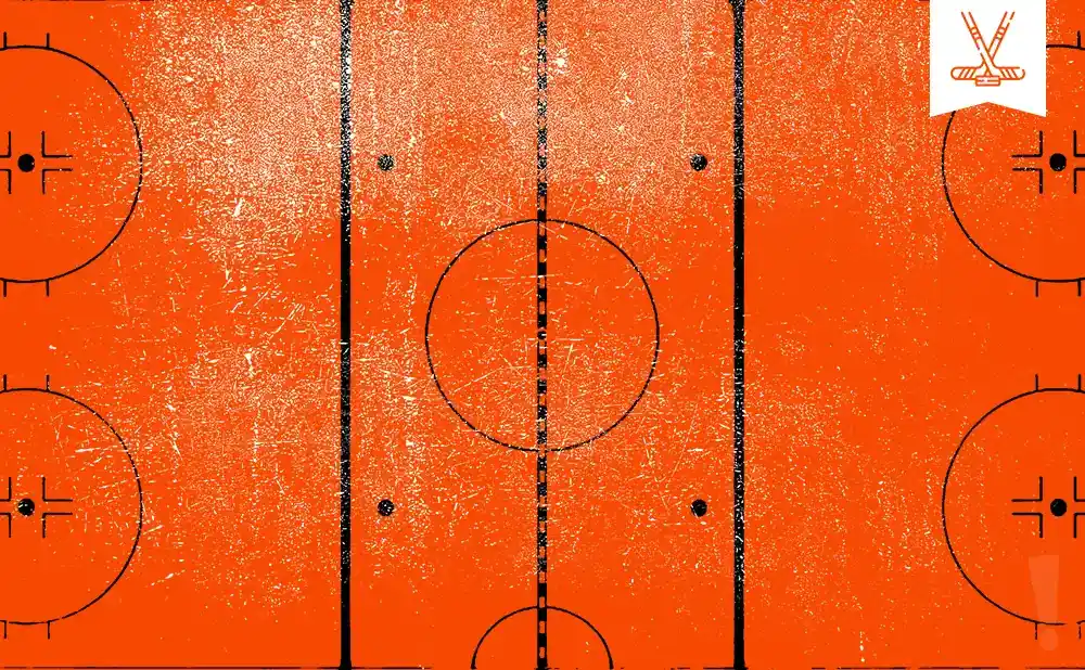 An orange hockey rink with black lines and markings, including circles and a center ice logo.