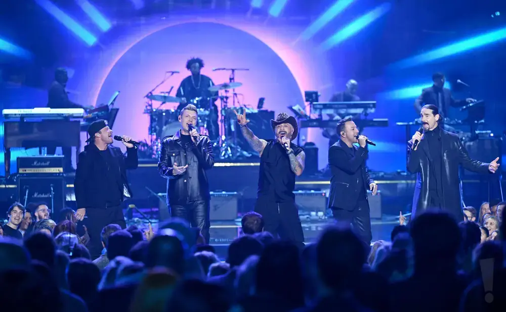 Backstreet Boys perform on stage with bright blue lighting and a live audience.