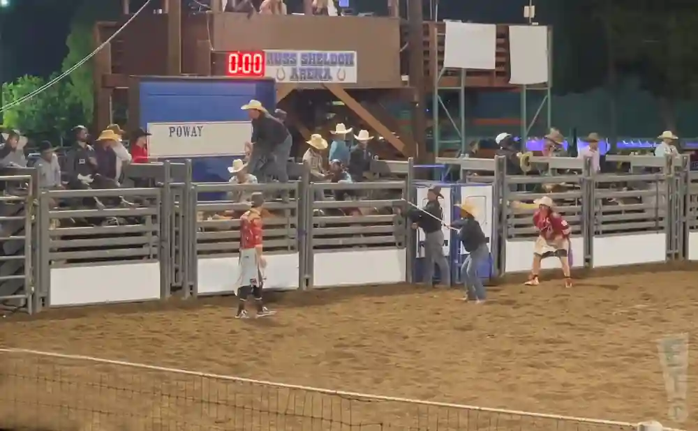 Rodeo clowns in a dirt arena wearing cowboy hats.