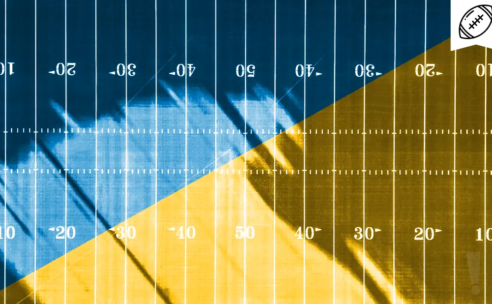 A football field split diagonally in blue and gold. White yard lines and numbers are visible.