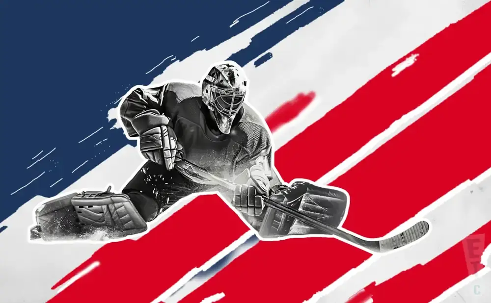 A hockey goalie in full gear dives to make a save with a hockey stick.