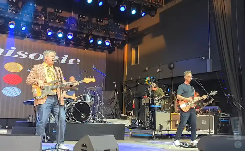 Musicians on stage with a banner that says 