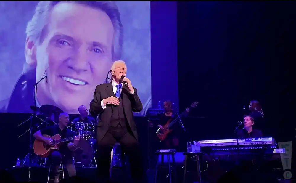 the righteous brothers singing on stage in a suit