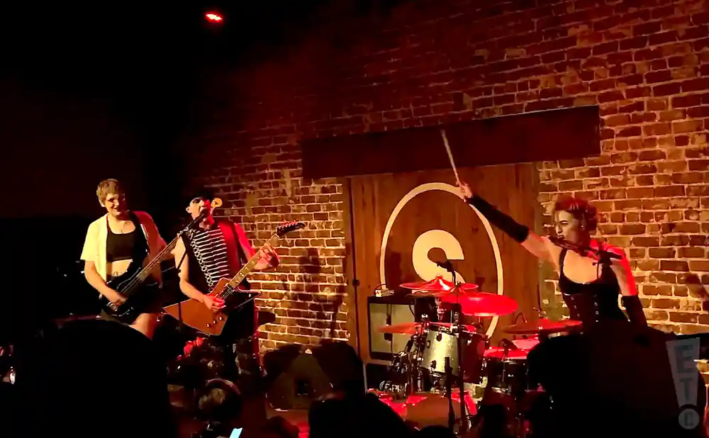 dresden dolls performing on stage in front of a brick backdrop.