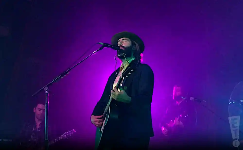 lord huron singing with purple and blue lights behind him