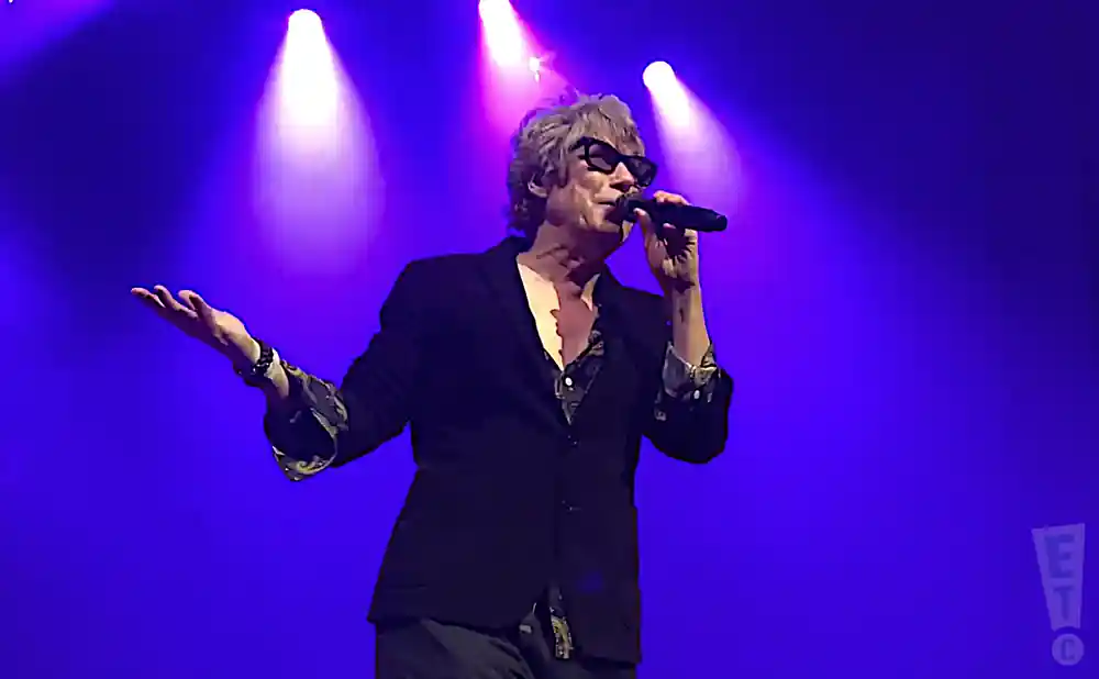the psychedelic furs lead singer performing on stage in blue light