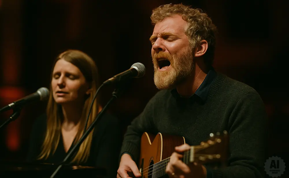 A man with a beard sings into a microphone while playing an acoustic guitar.