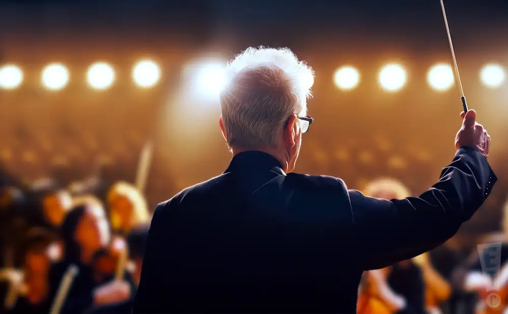 a rear view photo of osmo vanska conducting a symphony on stage before an audience