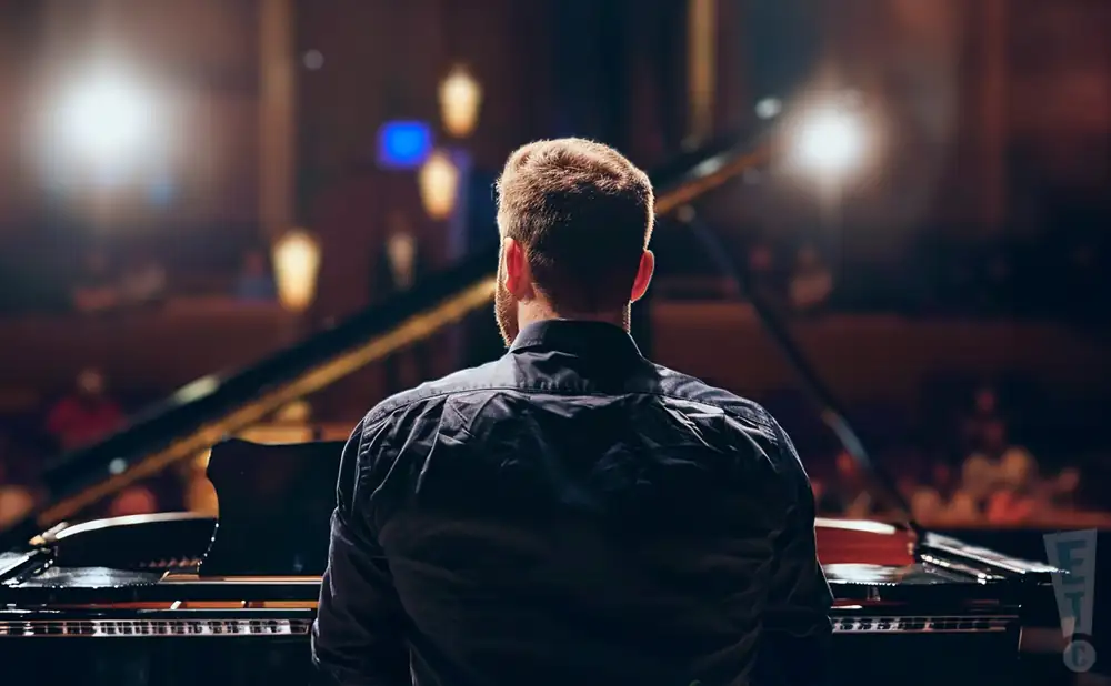 a rear-view photograph capturing american pianist peter dugan, performing on stage. 