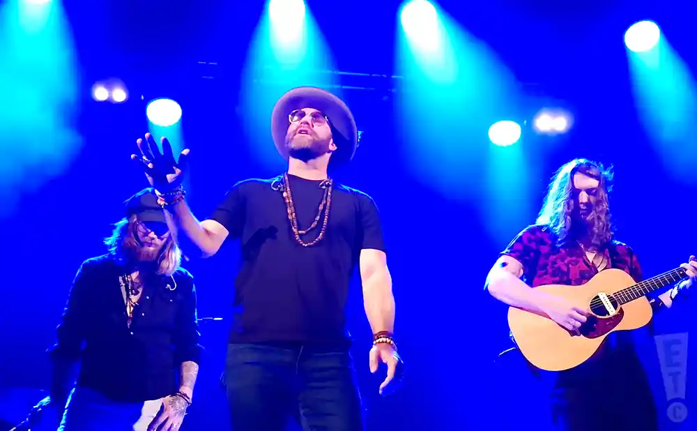 drake white singing on stage in front of blue lights