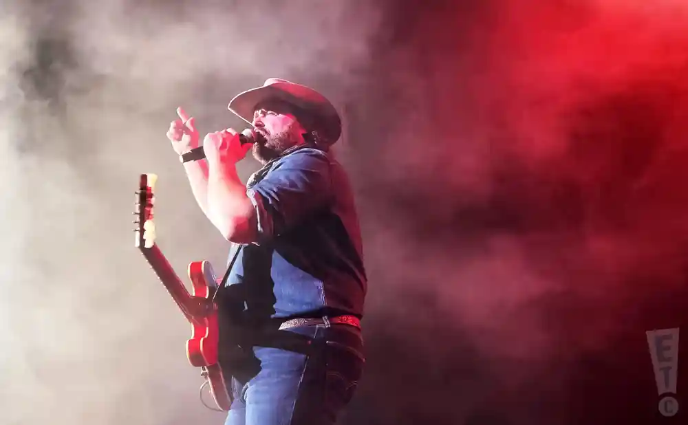 randy houser live on stage holding a guitar in fog