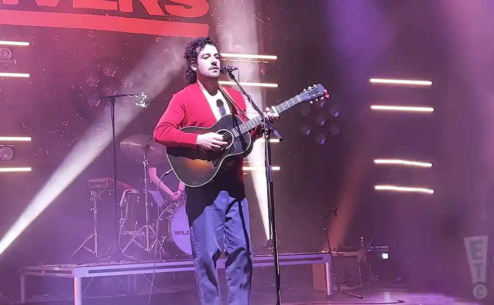 wild rivers singer playing the guitar in red shirt