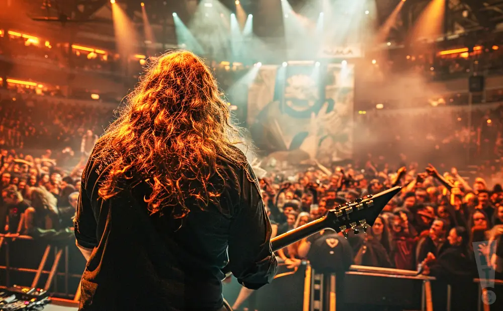 a rear view photo of opeth performing a concert on stage to a lively audience