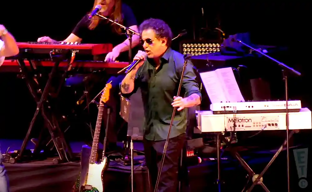 andres calamaro singing on stage in dark green shirt