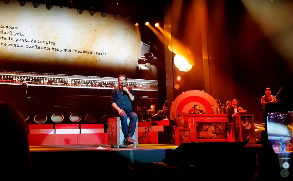 ricardo arjona sits on stage performing in madrid spain