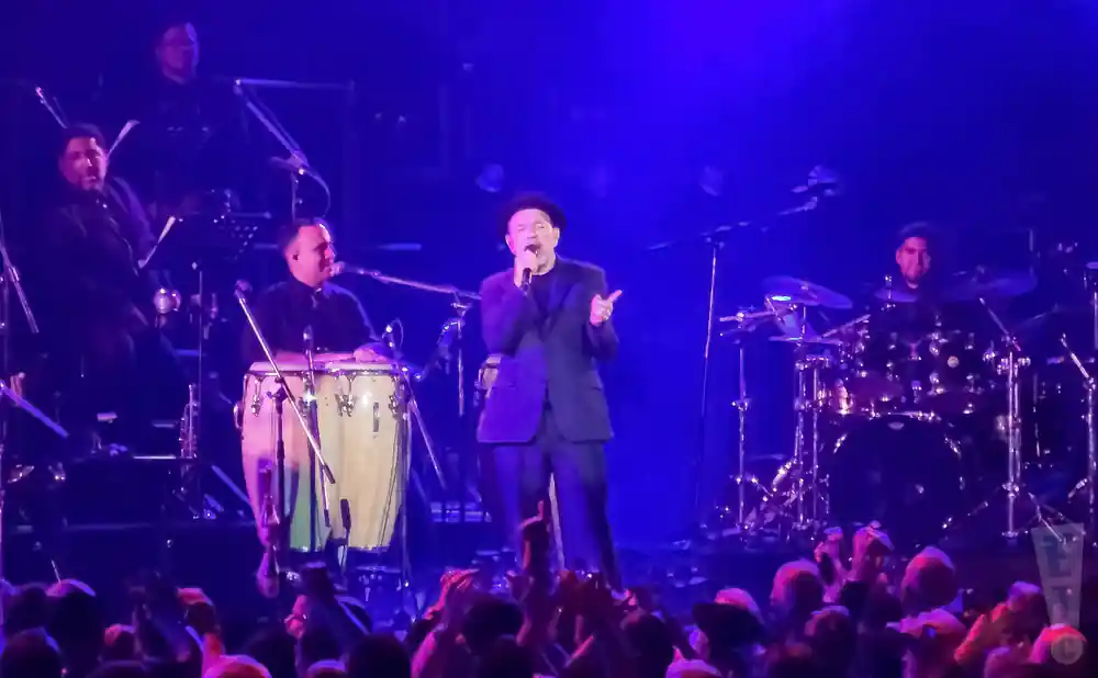 ruben blades performing on stage with band behind him