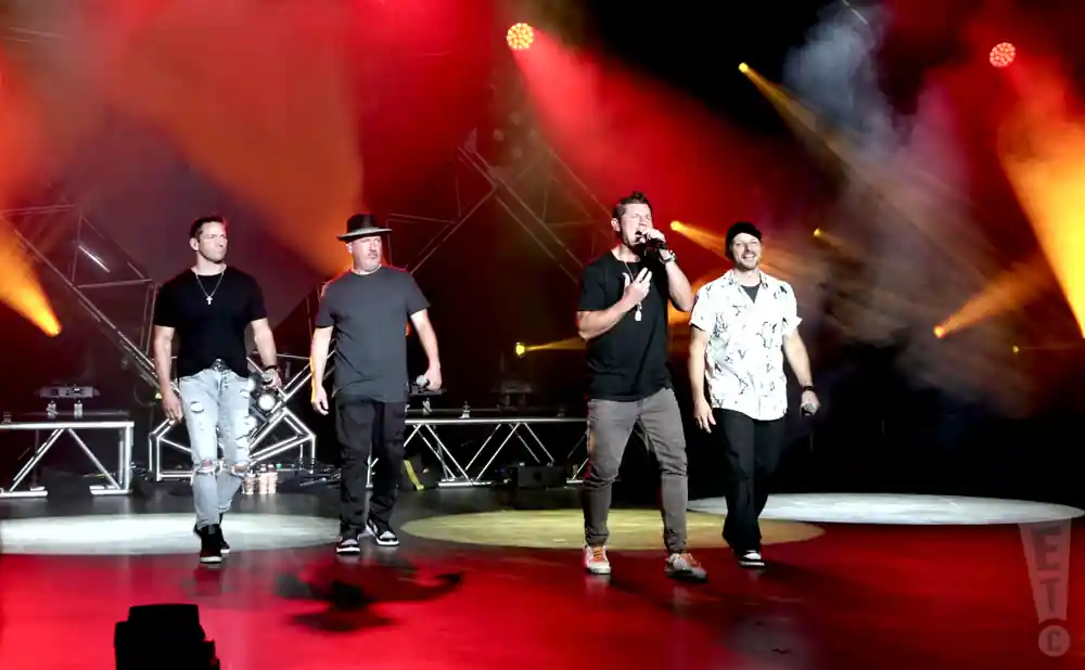 98 degrees peforming on stage in front of red light