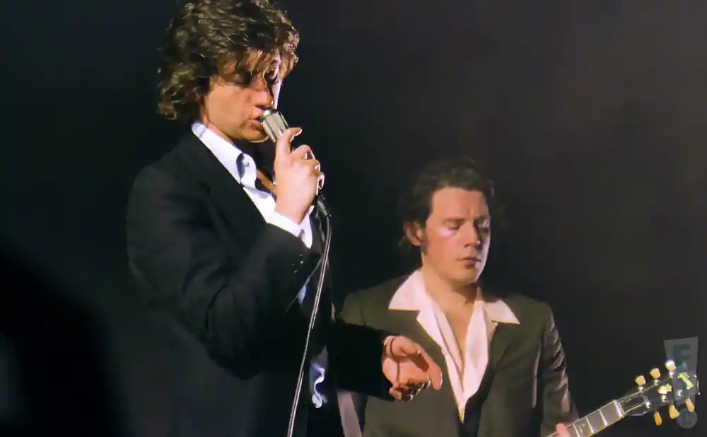 arctic monkeys lead singer and guitarist performing on stage