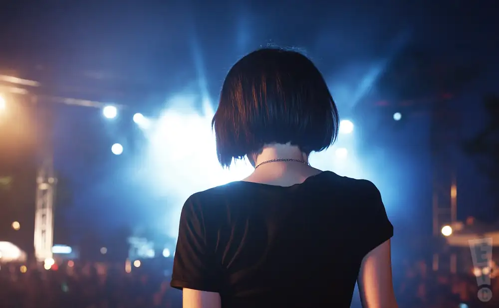 a rear view photo of crystal castles performing a concert on stage to a lively audience
