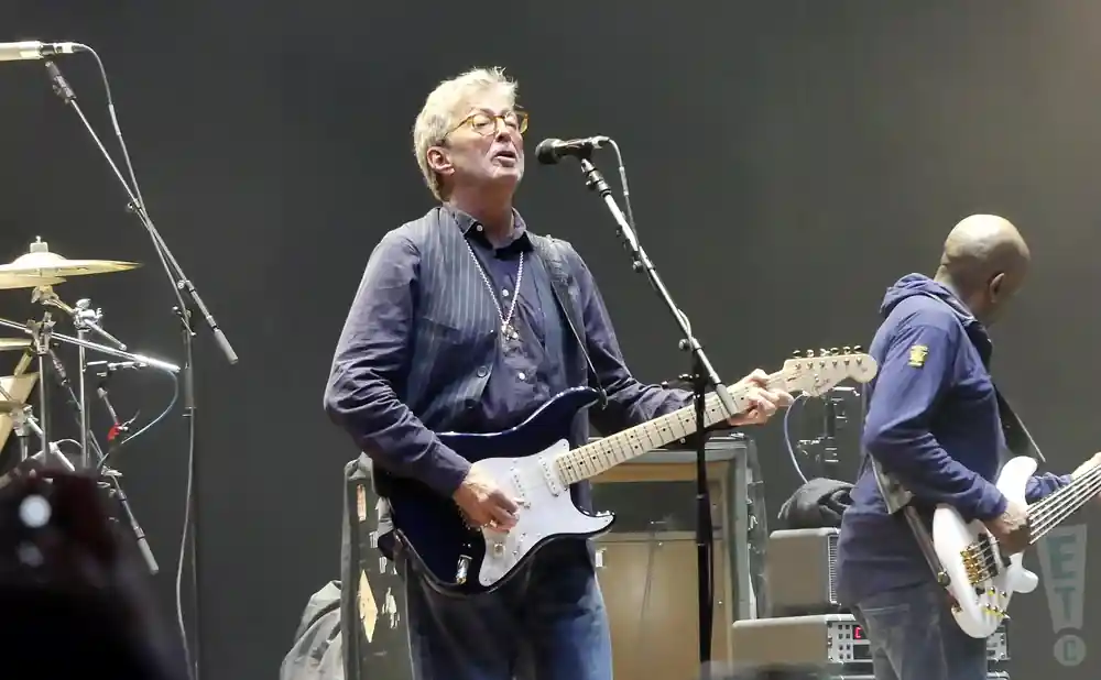 eric clapton playing guitiar besides band member