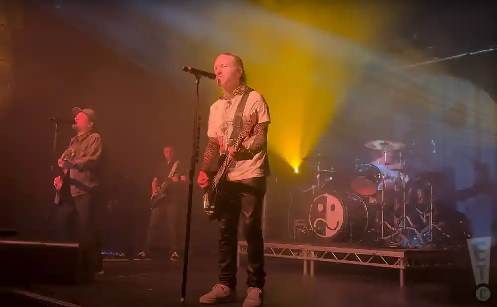 fall out boy performing on stage with white fog in background