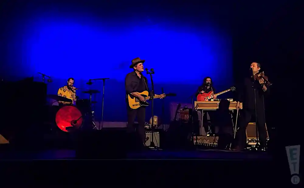 gregory alan isakov performing on stage in front of blue backdrop