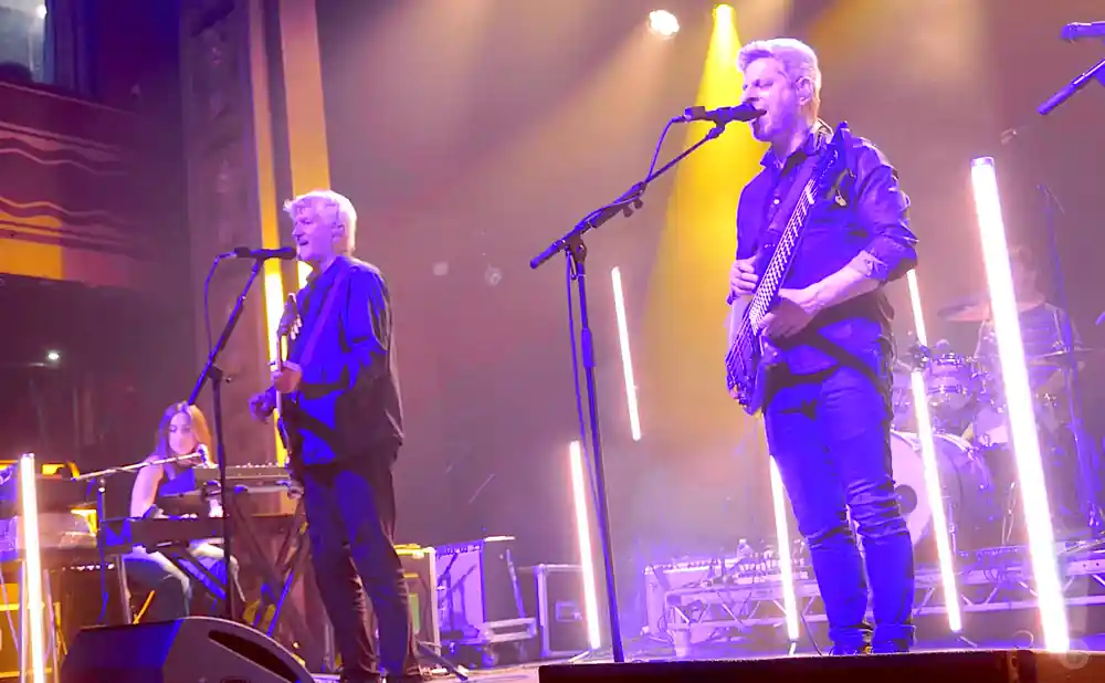 mike gordon playing the bass while singing on stage