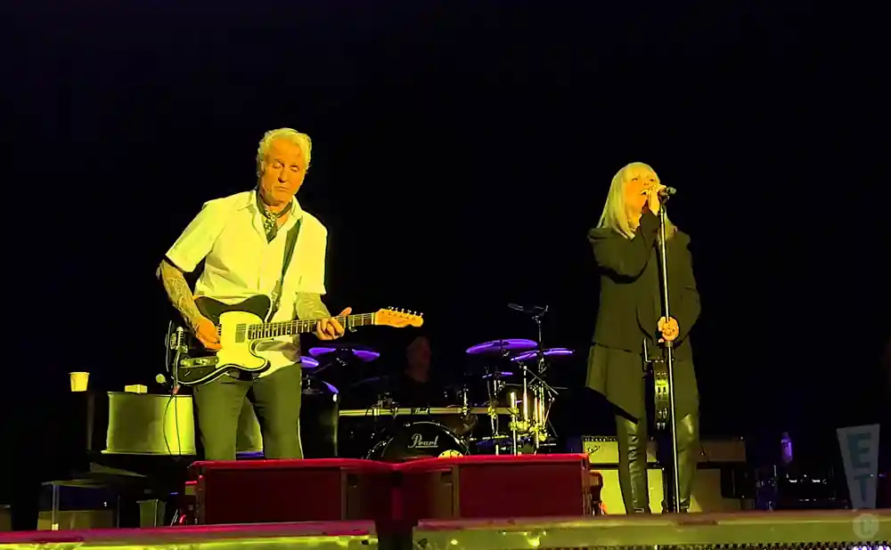 pat benatar performing on stage in front of black background