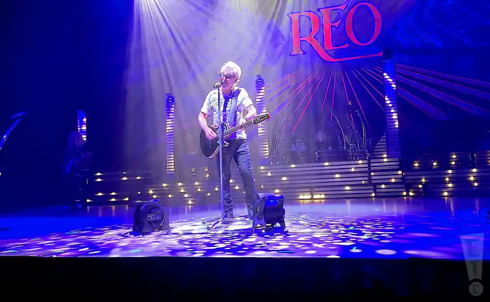 reo speedwagon singer performing on stage playing an electric guitar