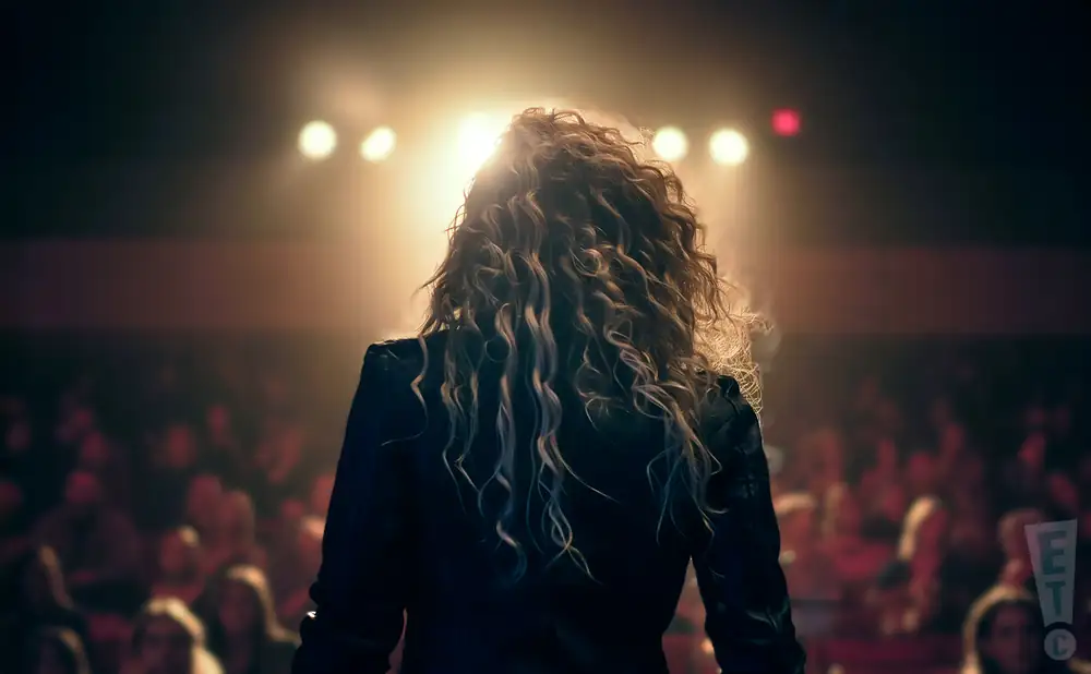 a rear view photo of sadie leigh performing a concert on stage to a lively audience