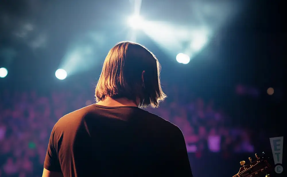 a rear view photo of steven wilson performing a concert on stage to a lively audience