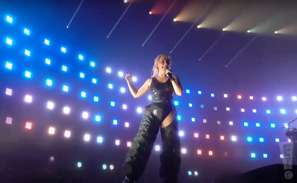 sylvan esso singing on stage with red white and blue lights behind her